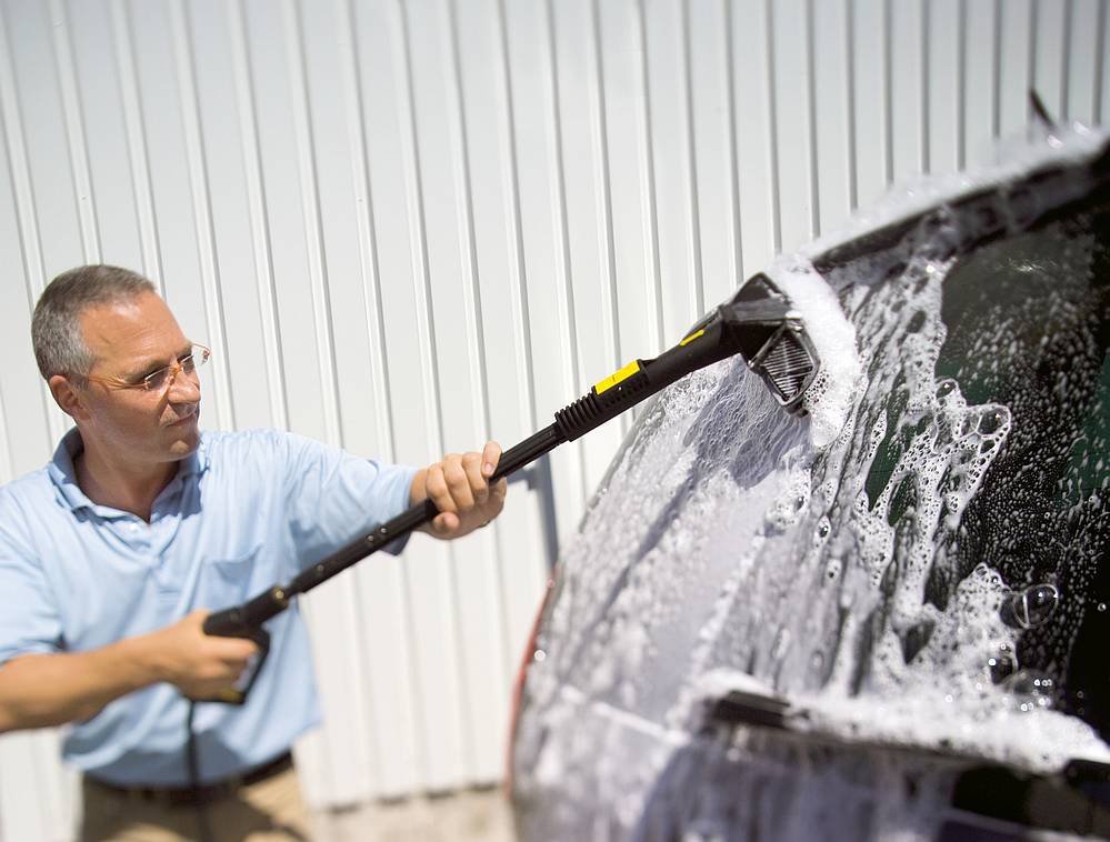 mezczyzna myje karoserie samochodu szczotka Karcher